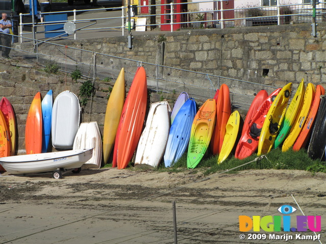 SX09003 Canoes and kayaks lined up against harbour wall